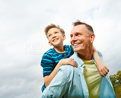 Buy stock photo Shot of a dad giving his son a piggyback outside