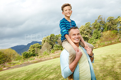 Buy stock photo Portrait of a dad giving his son a piggyback outside