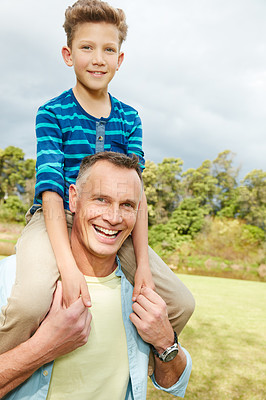 Buy stock photo Portrait of a dad giving his son a piggyback outside