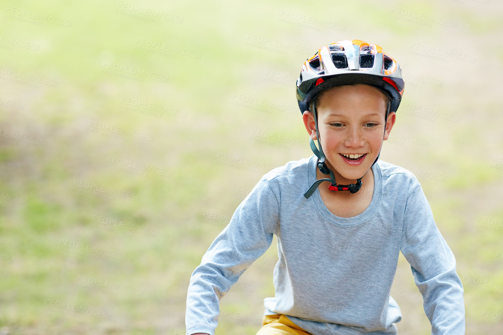 Buy stock photo Shot of a smiling boy riding his bicycle