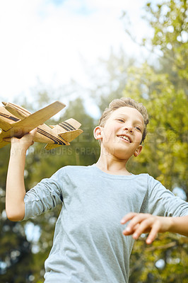 Buy stock photo Shot of a young boy running through a park with a toy airplane