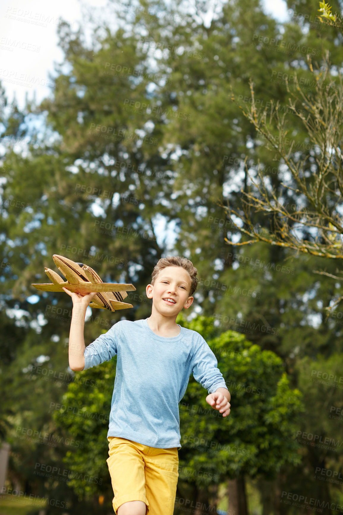 Buy stock photo Shot of a young boy running through a park with a toy airplane