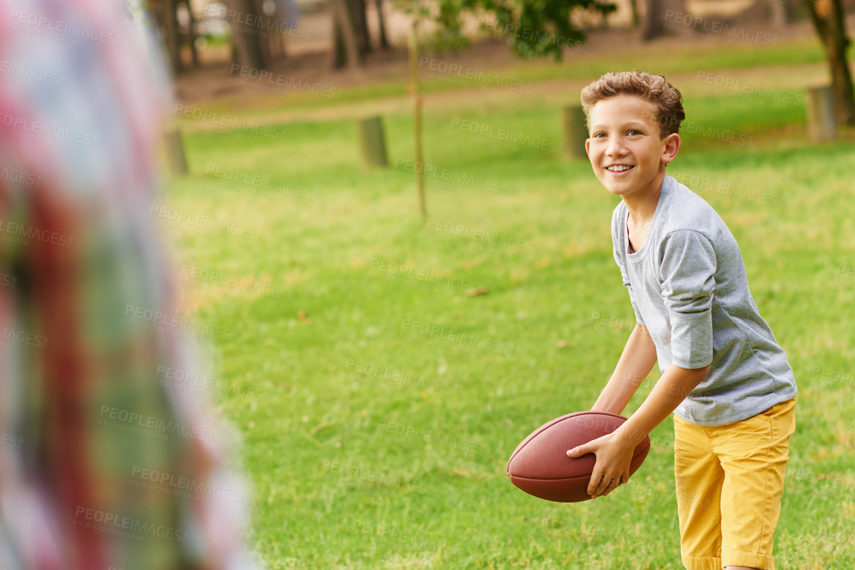 Buy stock photo Shot of a father and son throwing a football in a park