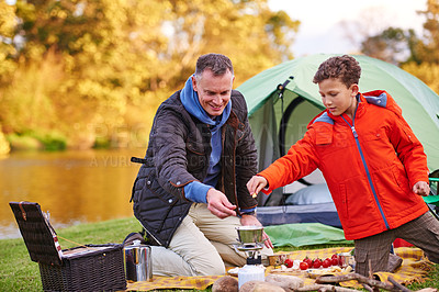Buy stock photo Shot of a father and son preparing a meal while camping