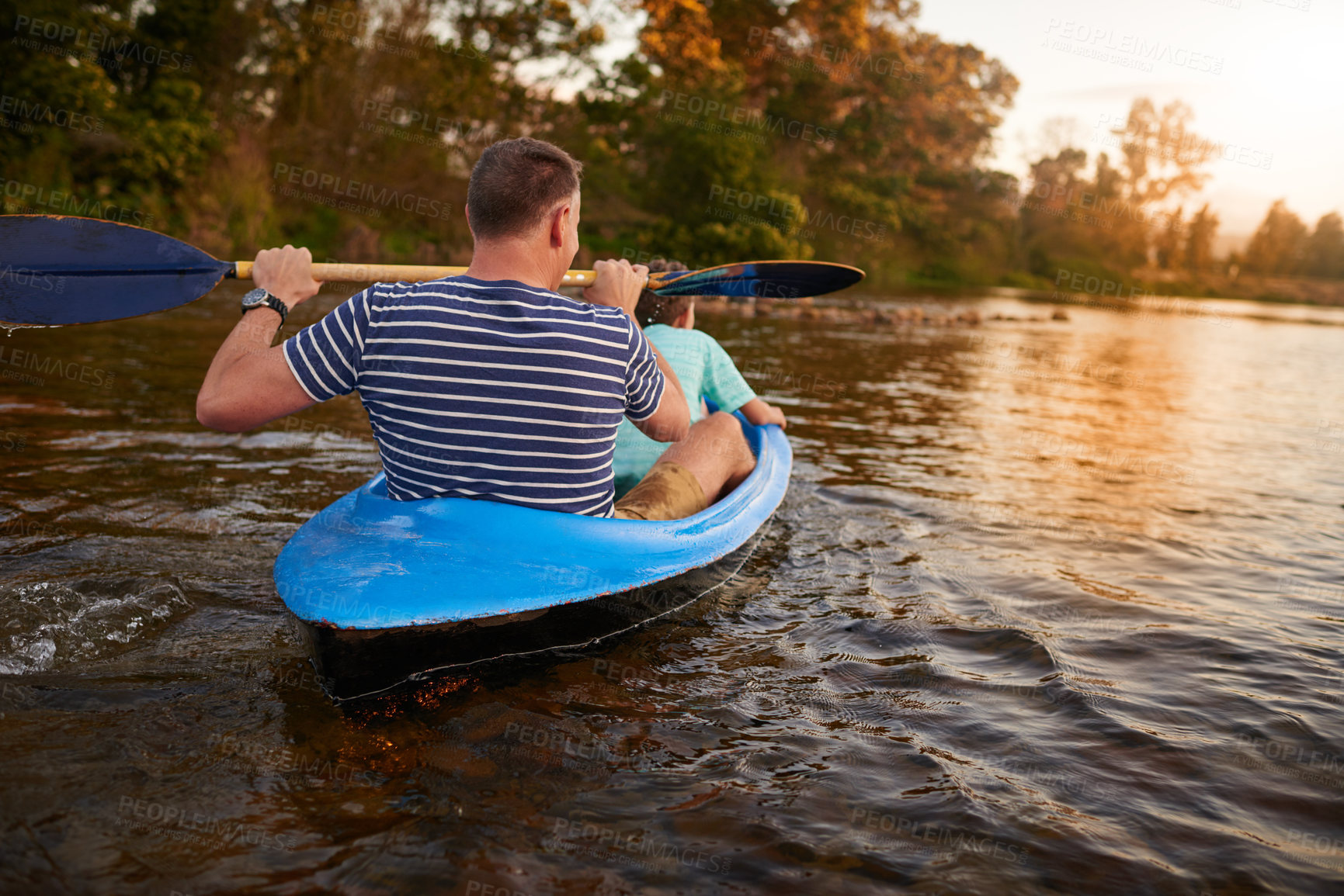 Buy stock photo Shot of a father and son rowing a boat together on a lake