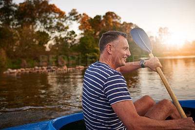 Buy stock photo Shot of a mature man rowing a boat on a lake