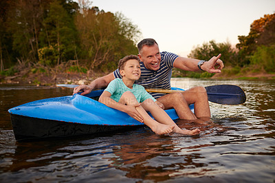 Buy stock photo Shot of a father and son sitting in a rowboat together on a lake