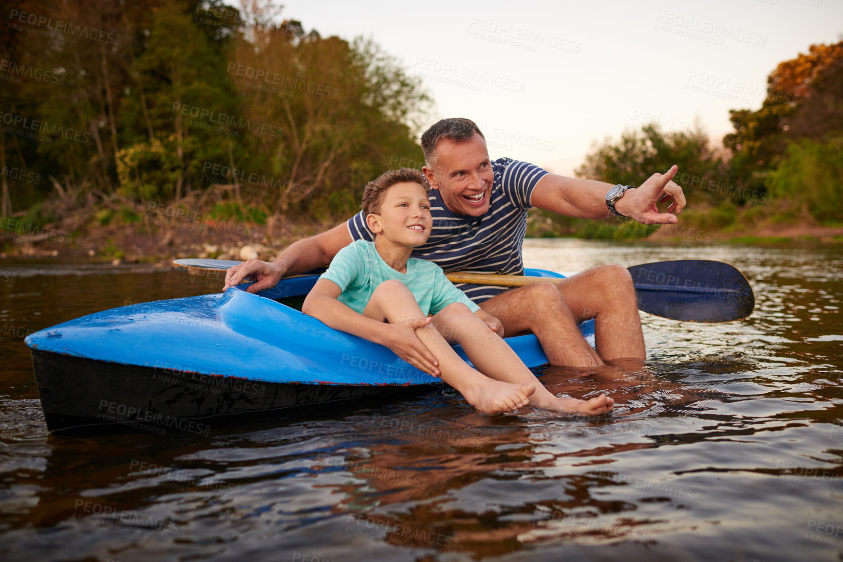 Buy stock photo Shot of a father and son sitting in a rowboat together on a lake