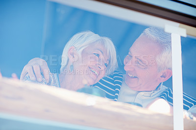 Buy stock photo Shot of a senior couple talking together at a cafe window