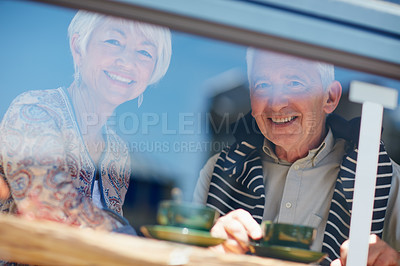 Buy stock photo Portrait of a senior couple talking together at a cafe window