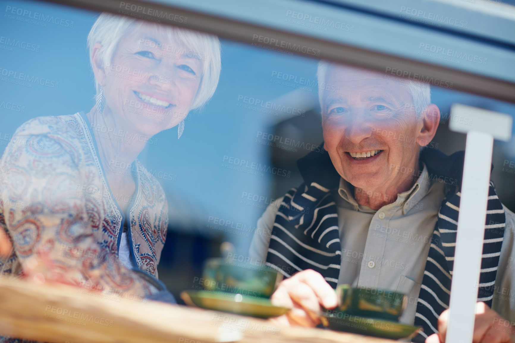 Buy stock photo Portrait of a senior couple talking together at a cafe window