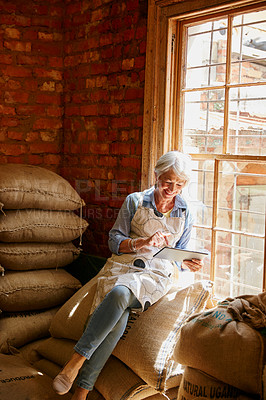 Buy stock photo Cropped shot of a senior woman using a tablet while working in a roastery