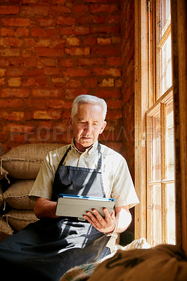 Buy stock photo Cropped shot of a senior man using a tablet while working in a roastery