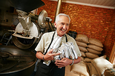 Buy stock photo Cropped shot of a senior man holding bags of coffee beans while working in a roastery
