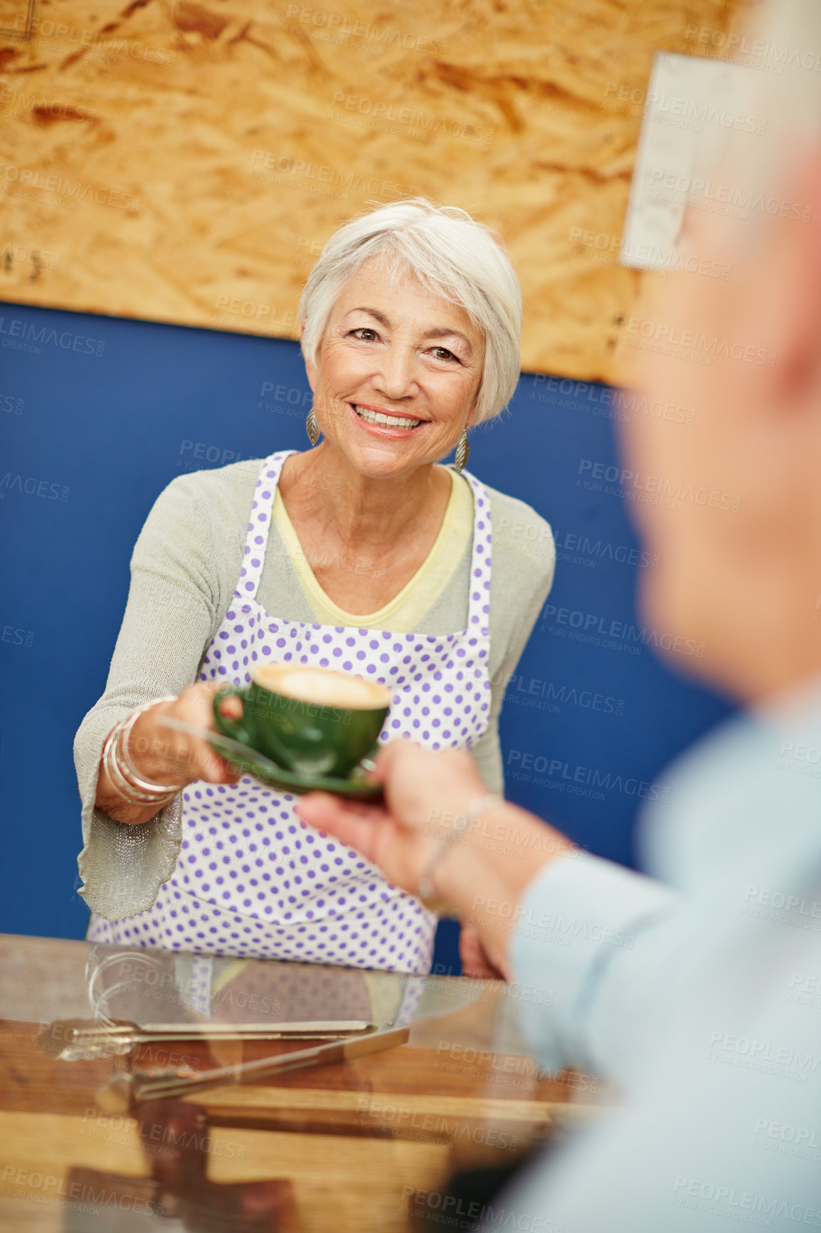 Buy stock photo Shot of a senior woman serving coffee in a cafe