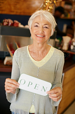 Buy stock photo Portrait of a senior woman holding up a sign on opening day of her small business