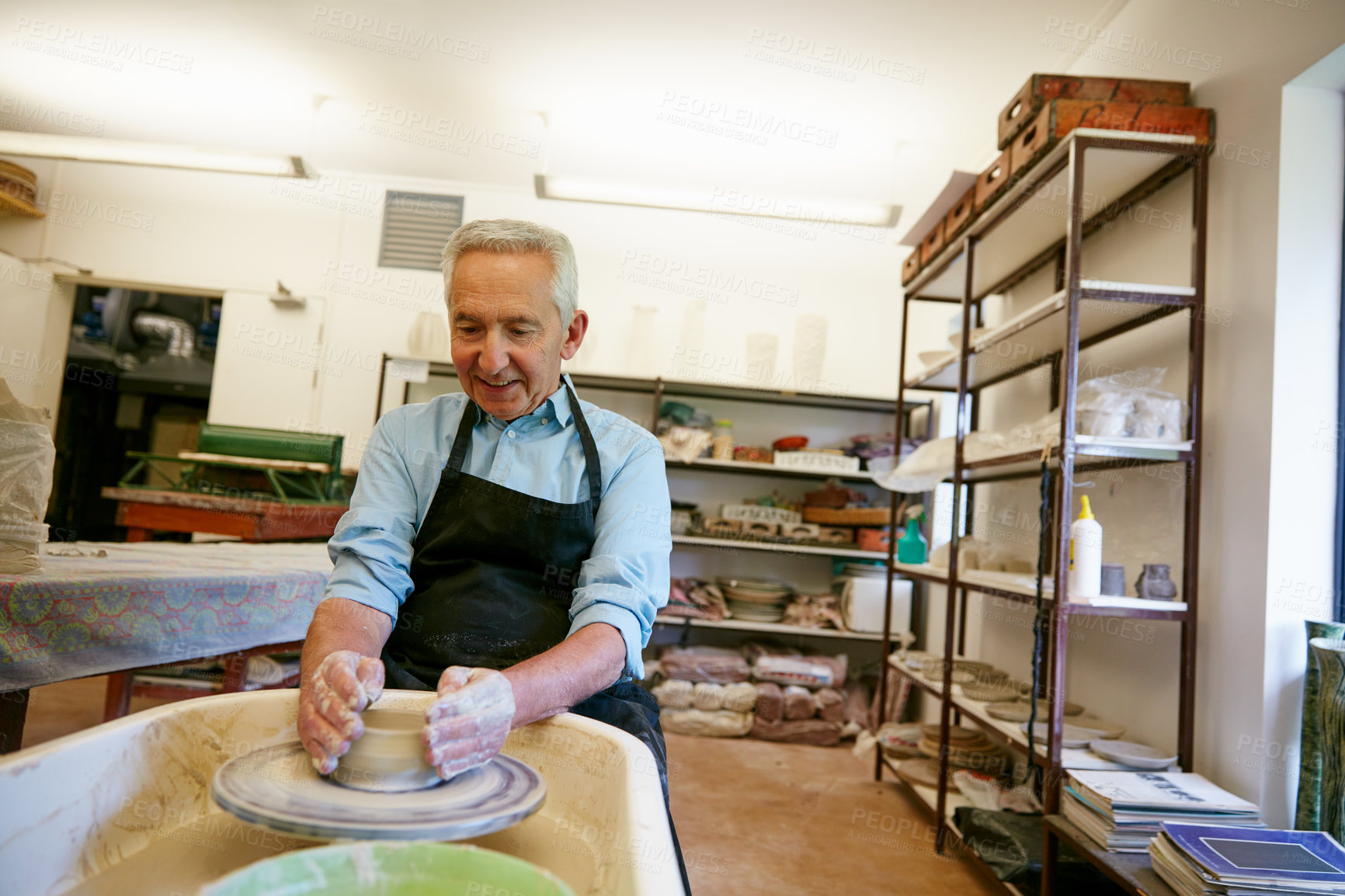 Buy stock photo Shot of a senior man making a ceramic pot in a workshop