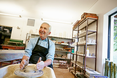 Buy stock photo Shot of a senior man making a ceramic pot in a workshop