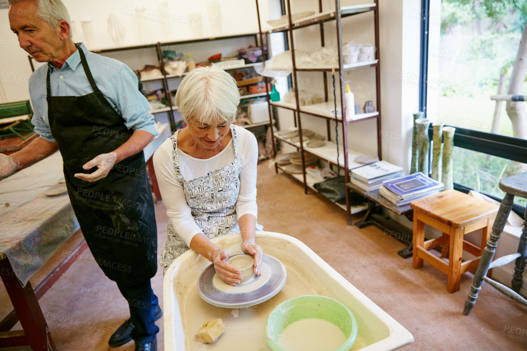 Buy stock photo Shot of a senior couple working with ceramics in a workshop