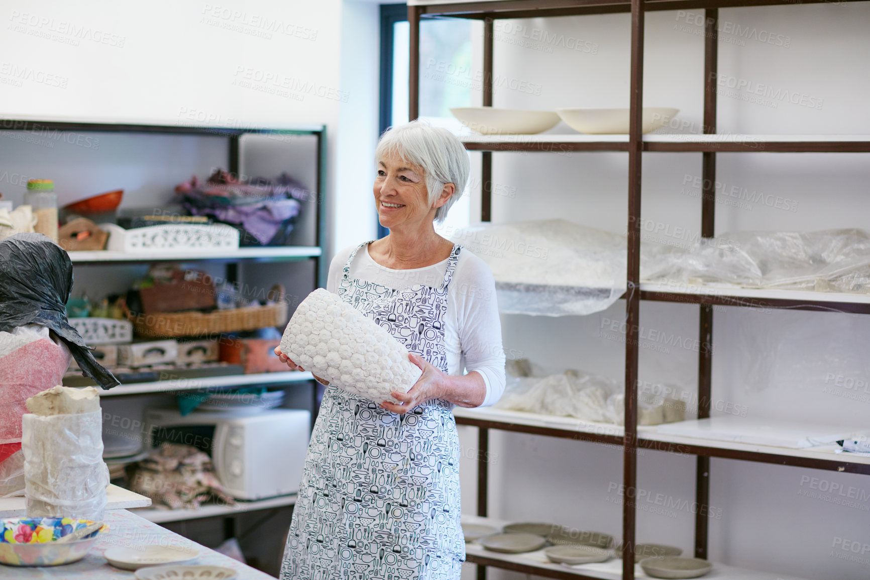 Buy stock photo Shot of a senior woman making a ceramic pot in a workshop