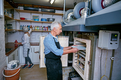 Buy stock photo Shot of a senior couple working with ceramics in a workshop