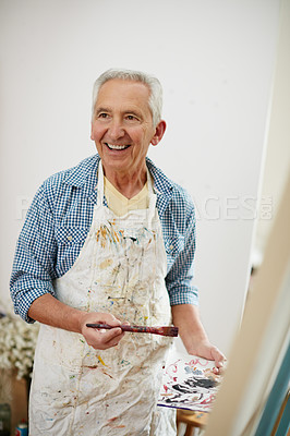 Buy stock photo Shot of a senior man working on a painting at home