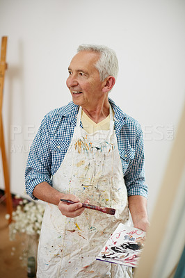 Buy stock photo Shot of a senior man working on a painting at home
