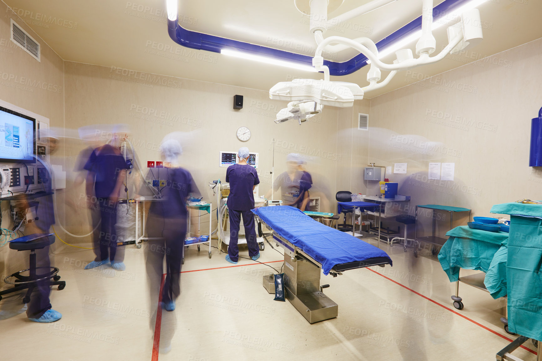 Buy stock photo Shot of a team of surgeons prepping an operating room for a surgery