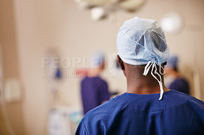 Buy stock photo Rearview shot of a surgeon standing in an operating room