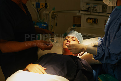 Buy stock photo Shot of a surgeon preparing a patient for her surgery