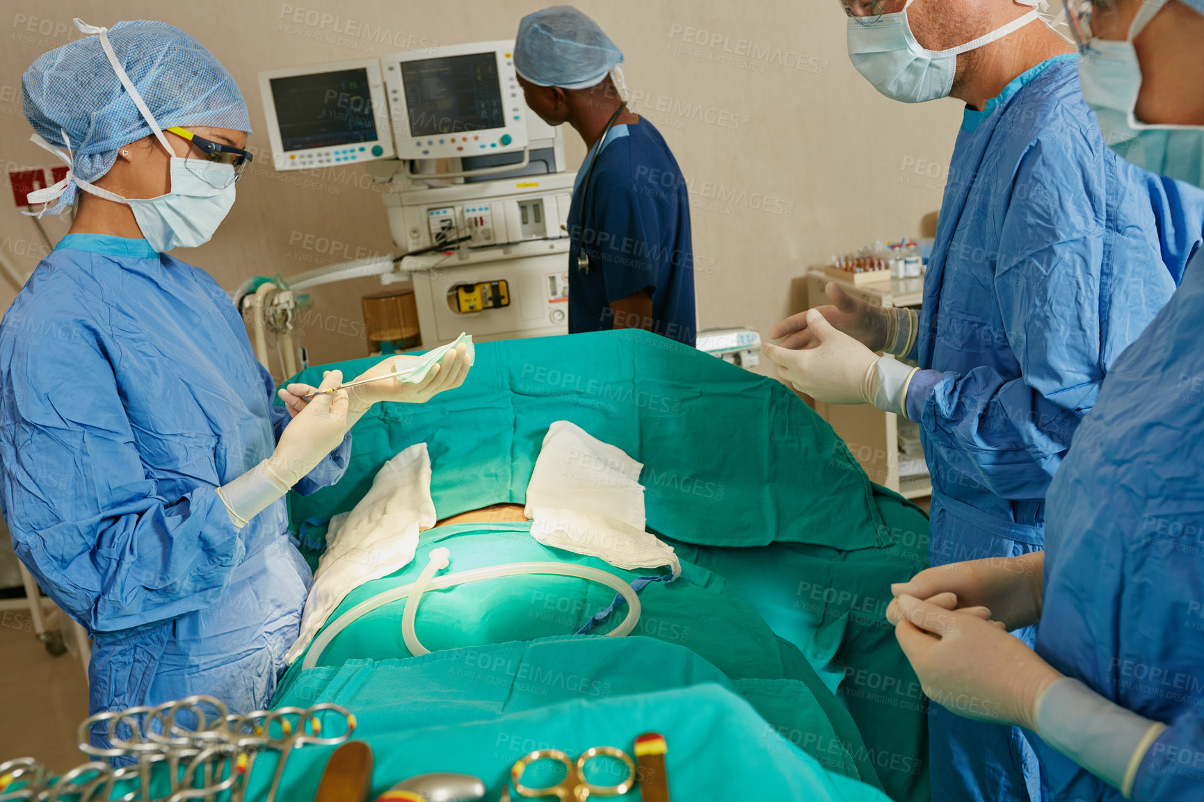 Buy stock photo Shot of a team of surgeons preparing for a surgical procedure