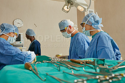 Buy stock photo Shot of a team of surgeons performing a surgery in an operating room