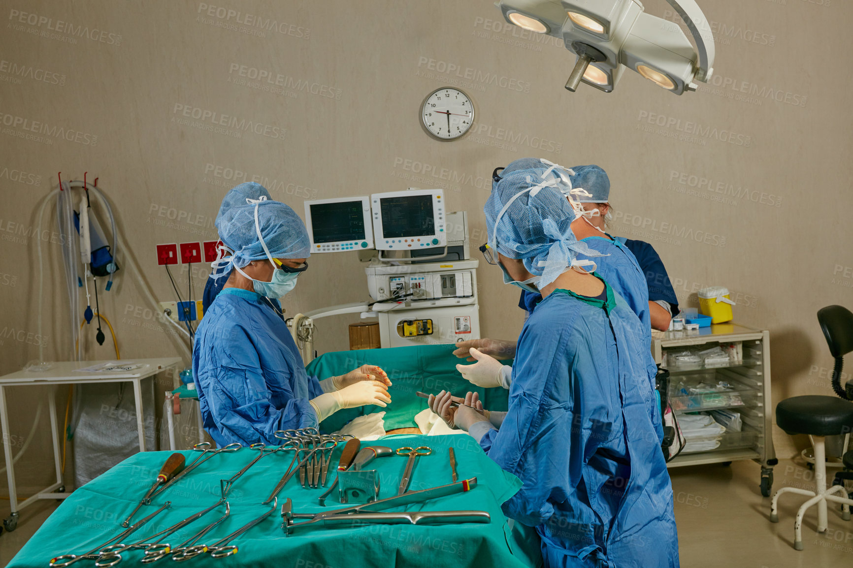 Buy stock photo Shot of a team of surgeons performing a surgery in an operating room