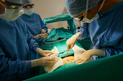 Buy stock photo Shot of a surgeon making an incision with a scalpel on a patient