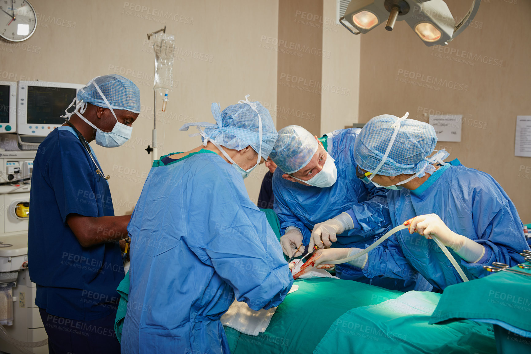 Buy stock photo Shot of a team of surgeons performing a surgery in an operating room