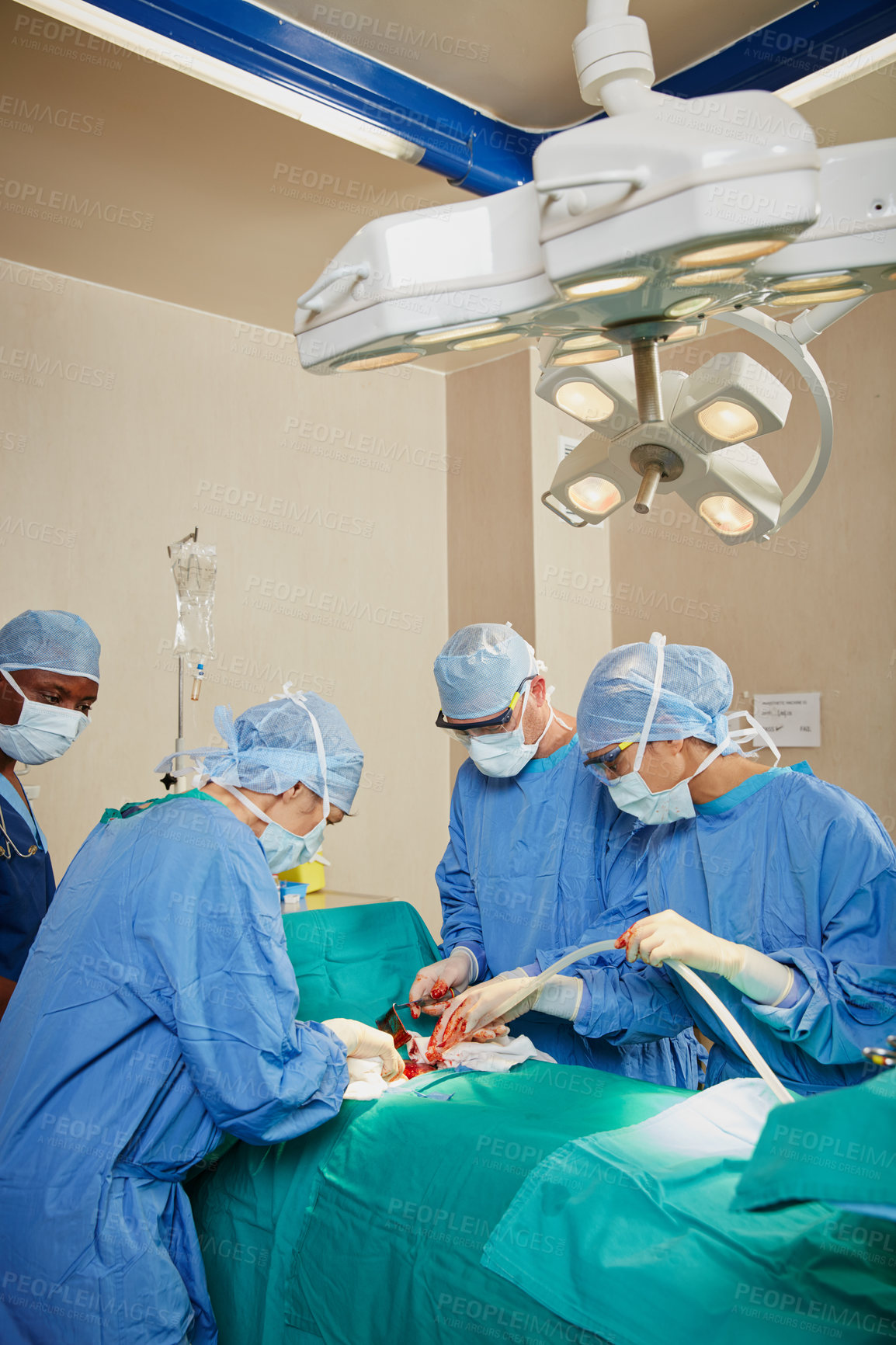 Buy stock photo Shot of a team of surgeons performing a surgery in an operating room