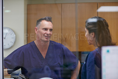 Buy stock photo Shot of two medical practitioners having a conversation in a hospital