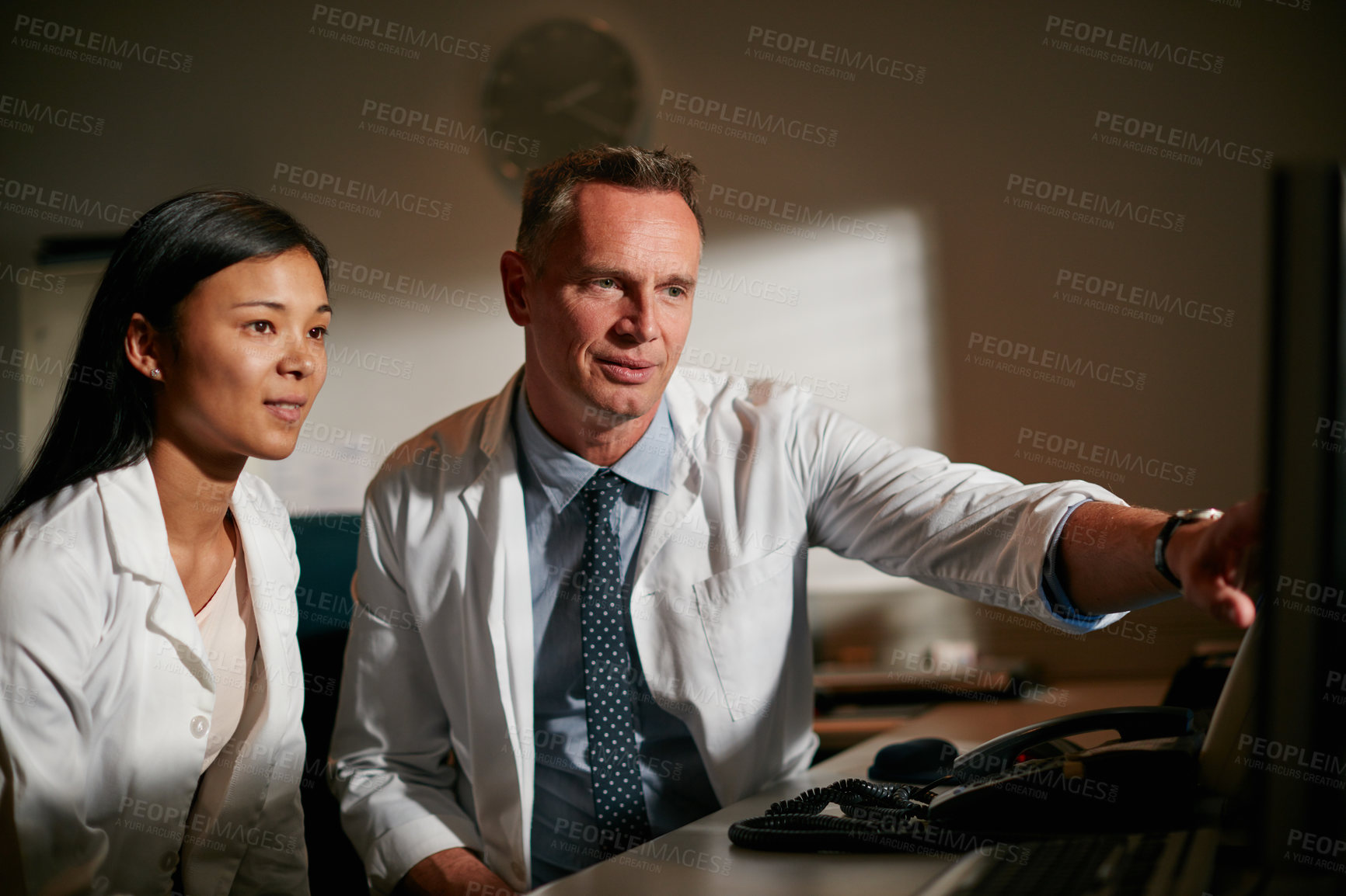 Buy stock photo Cropped shot of doctors working late into the night