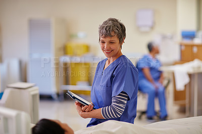 Buy stock photo Shot of a nurse standing by her patient's bedside