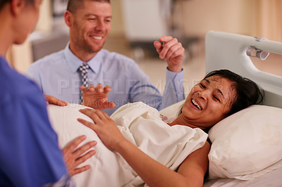 Buy stock photo Shot of a nurse talking to a pregnant woman and her husband