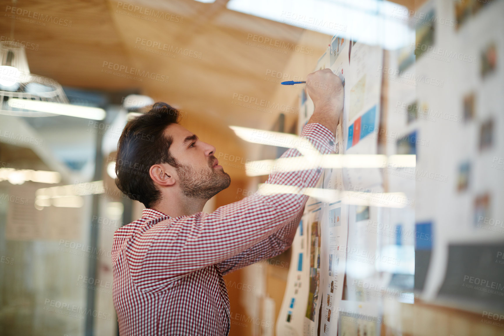 Buy stock photo Shot of a young businessman working on a project