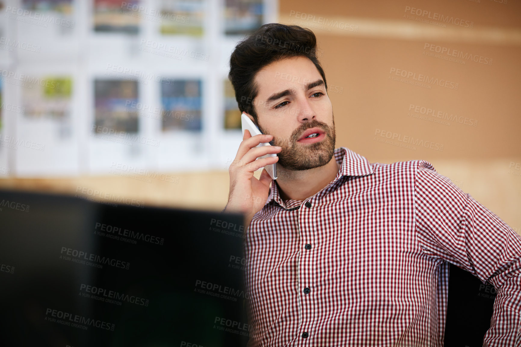 Buy stock photo Shot of a businessman using his cellphone while sitting at his desk