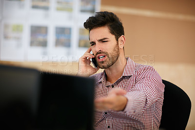Buy stock photo Shot of a businessman using his cellphone while sitting at his desk