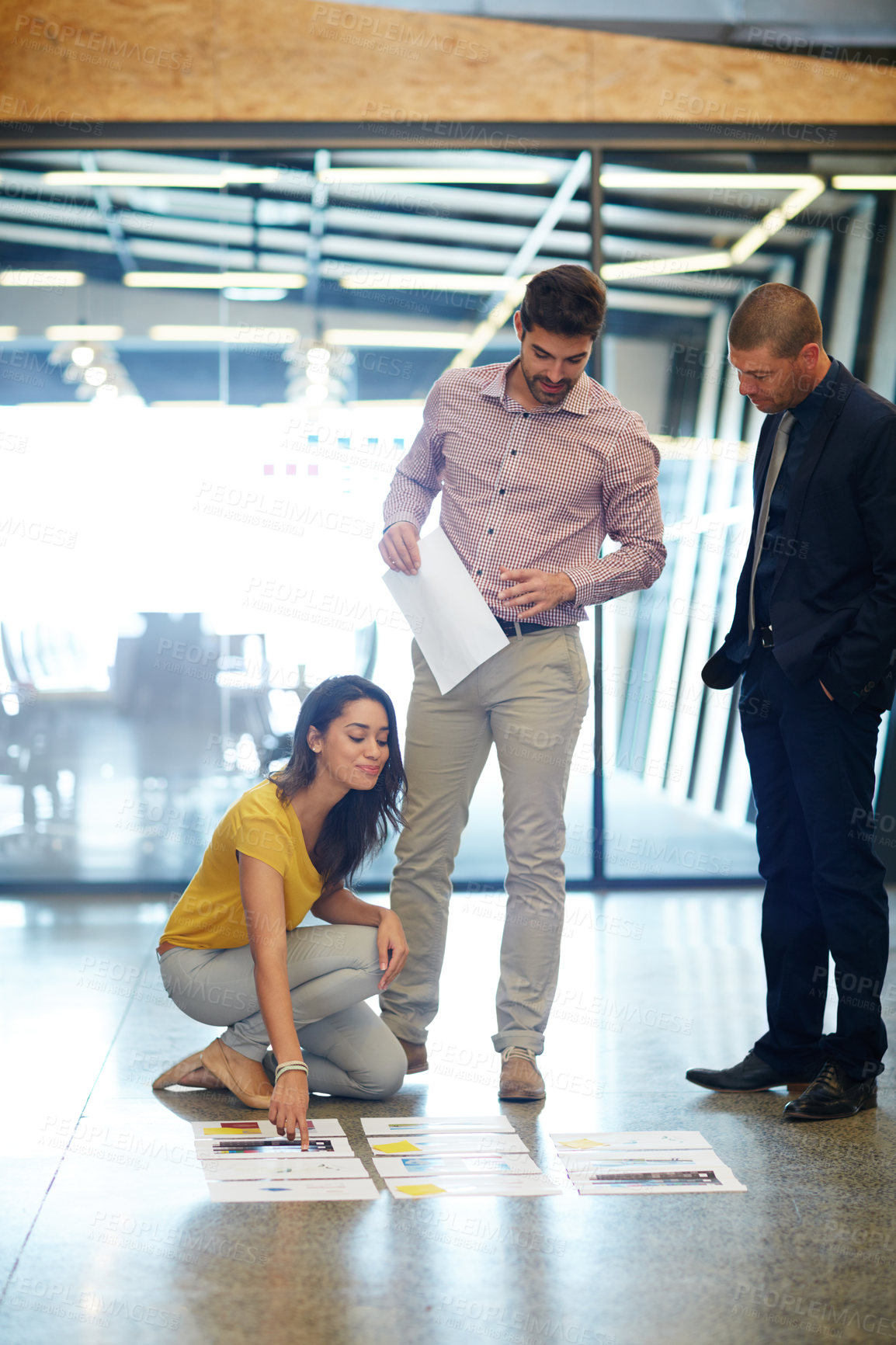 Buy stock photo Full length shot of three businesspeople looking over some paperwork