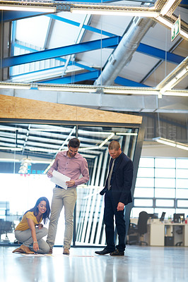 Buy stock photo Full length shot of three businesspeople looking over some paperwork