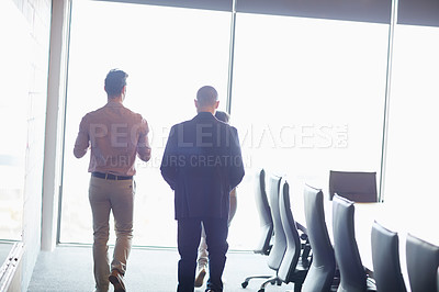 Buy stock photo Shot of three businesspeople walking into the boardroom