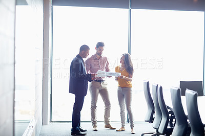 Buy stock photo Full length shot of three businesspeople talking in the boardroom