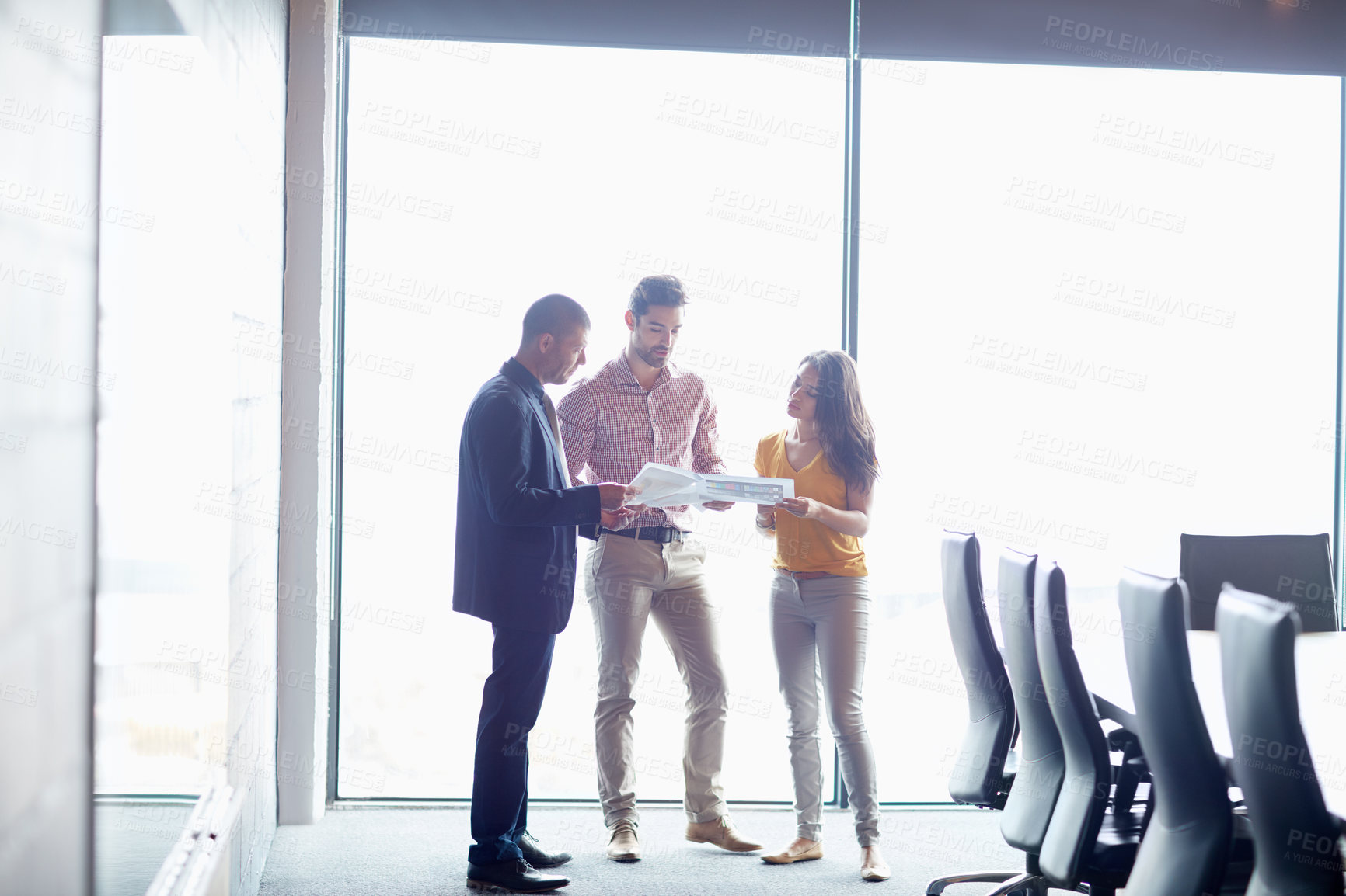 Buy stock photo Full length shot of three businesspeople talking in the boardroom