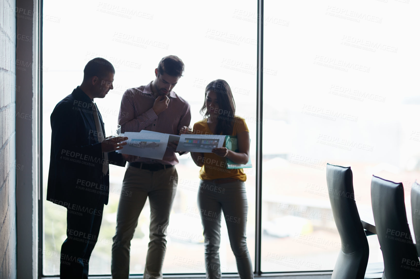 Buy stock photo Cropped shot of three businesspeople talking in the boardroom