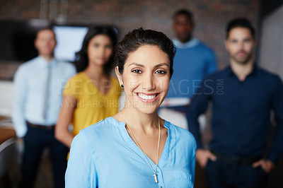 Buy stock photo Cropped portrait of a businesswoman standing in the workplace with her colleagues in the background